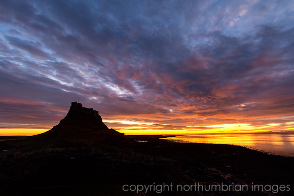 Lindisfarne in a fiery silhouette